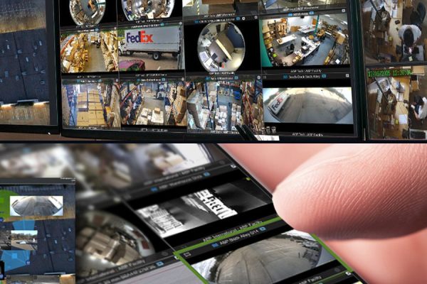 An IPTECHVIEW multi-site management workstation on three monitors above a hand holding a phone showing live camera views