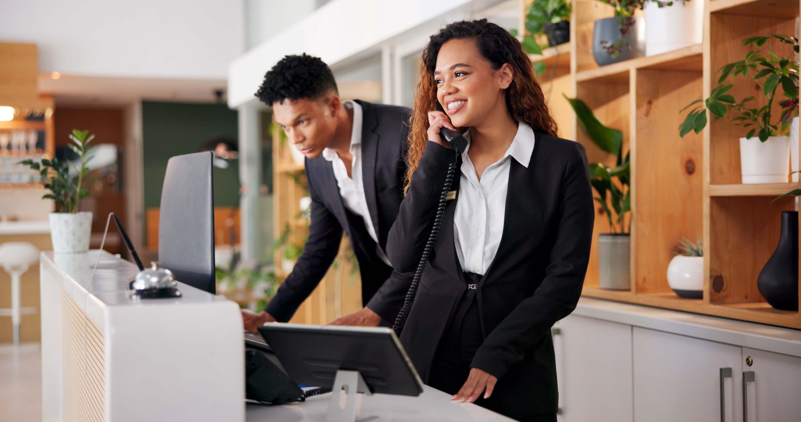 Hotel front desk staff answering a call — the rooms keep their existing phones